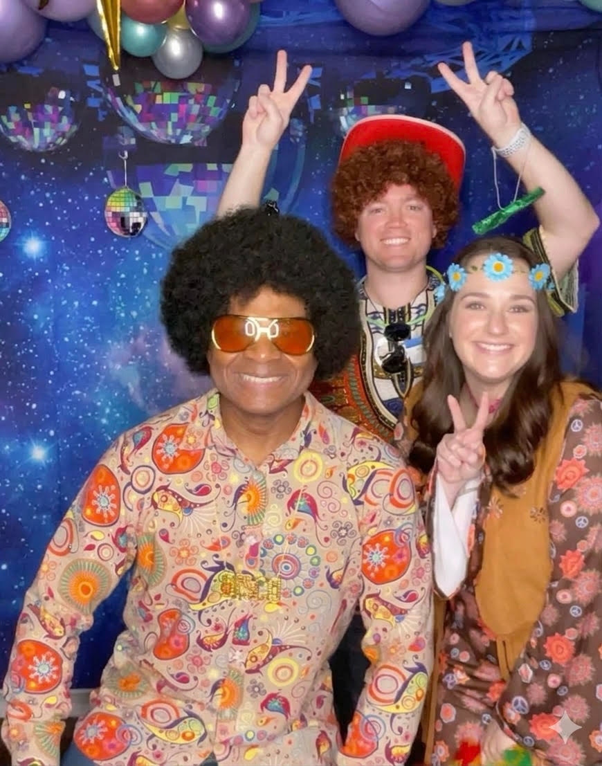 Cecil Blanton's 70s-themed 60th birthday party with disco ball backdrop, afro wigs, and colorful 70s costumes