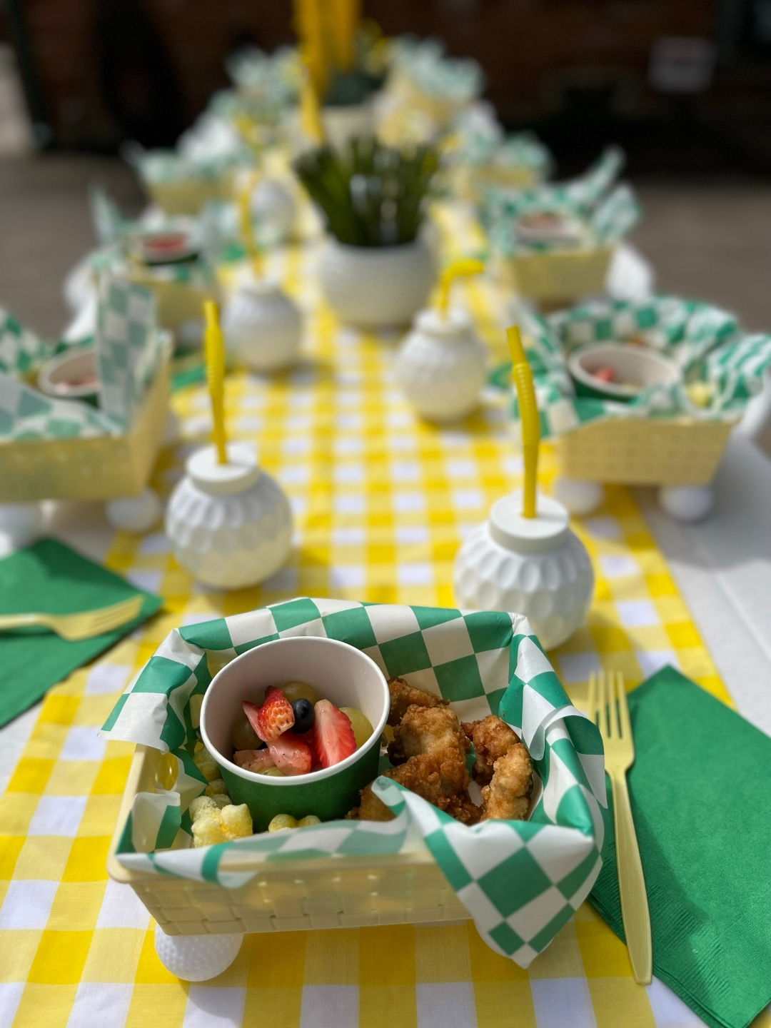 Golf party closeup of individual food basket with fruit and chicken