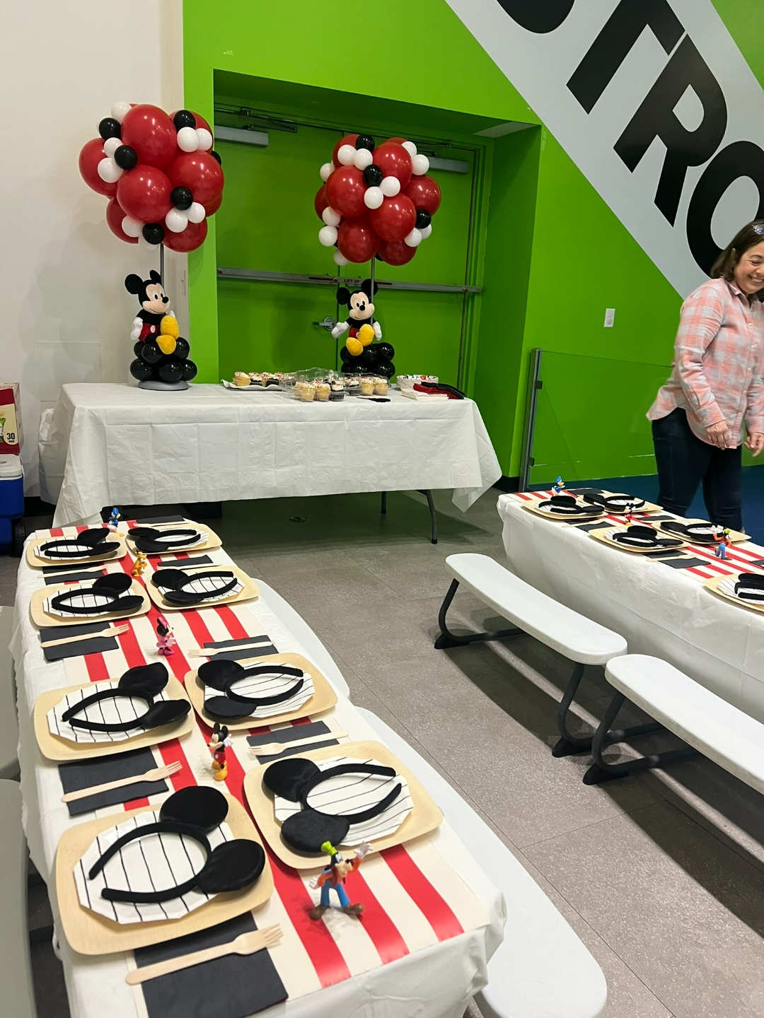 Mickey Mouse birthday party with red black and white balloon topiary trees and Disney character figurines on table